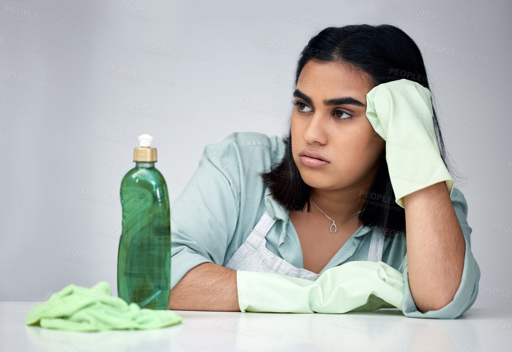 Buy stock photo Frustrated, woman and thinking about cleaning with gloves, detergent and cloth for house chores in studio. Depressed, female person and spray bottle with chemicals from anxiety for bacteria and germs