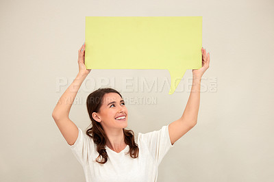 Buy stock photo Shot of a young woman holding up a sign against a white background