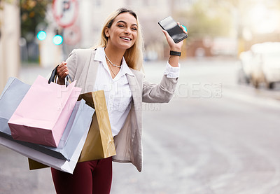 Buy stock photo Cropped shot of an attractive young woman waving down her her cab is while out shopping in the city with cellphone in hand