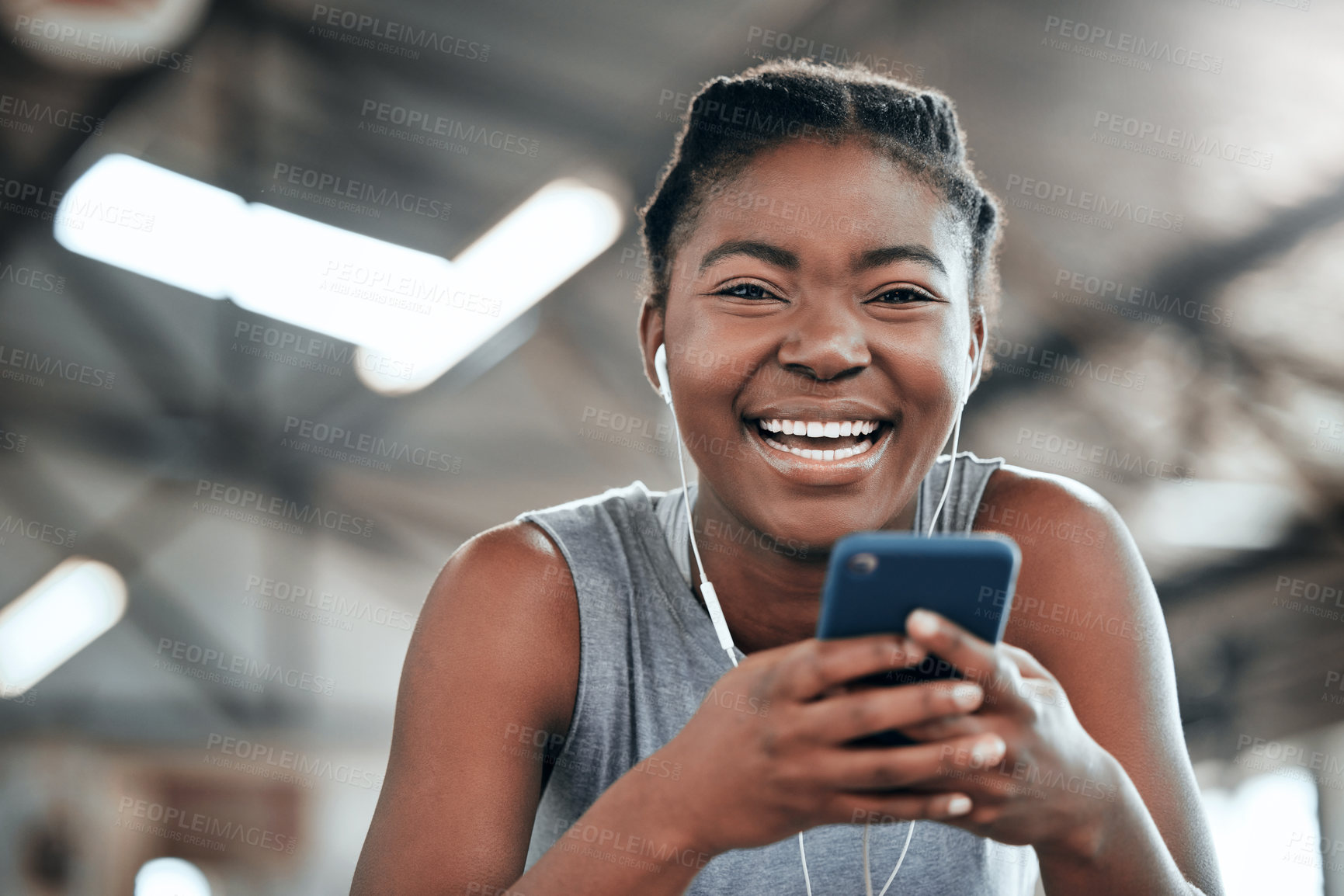 Buy stock photo Phone, earphones and portrait of black woman in gym for fitness, sports or exercise. Smartphone, face and African female athlete on social media break, web and music after workout, training and smile