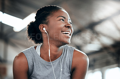 Buy stock photo Shot of a happy woman using earphones at the gym