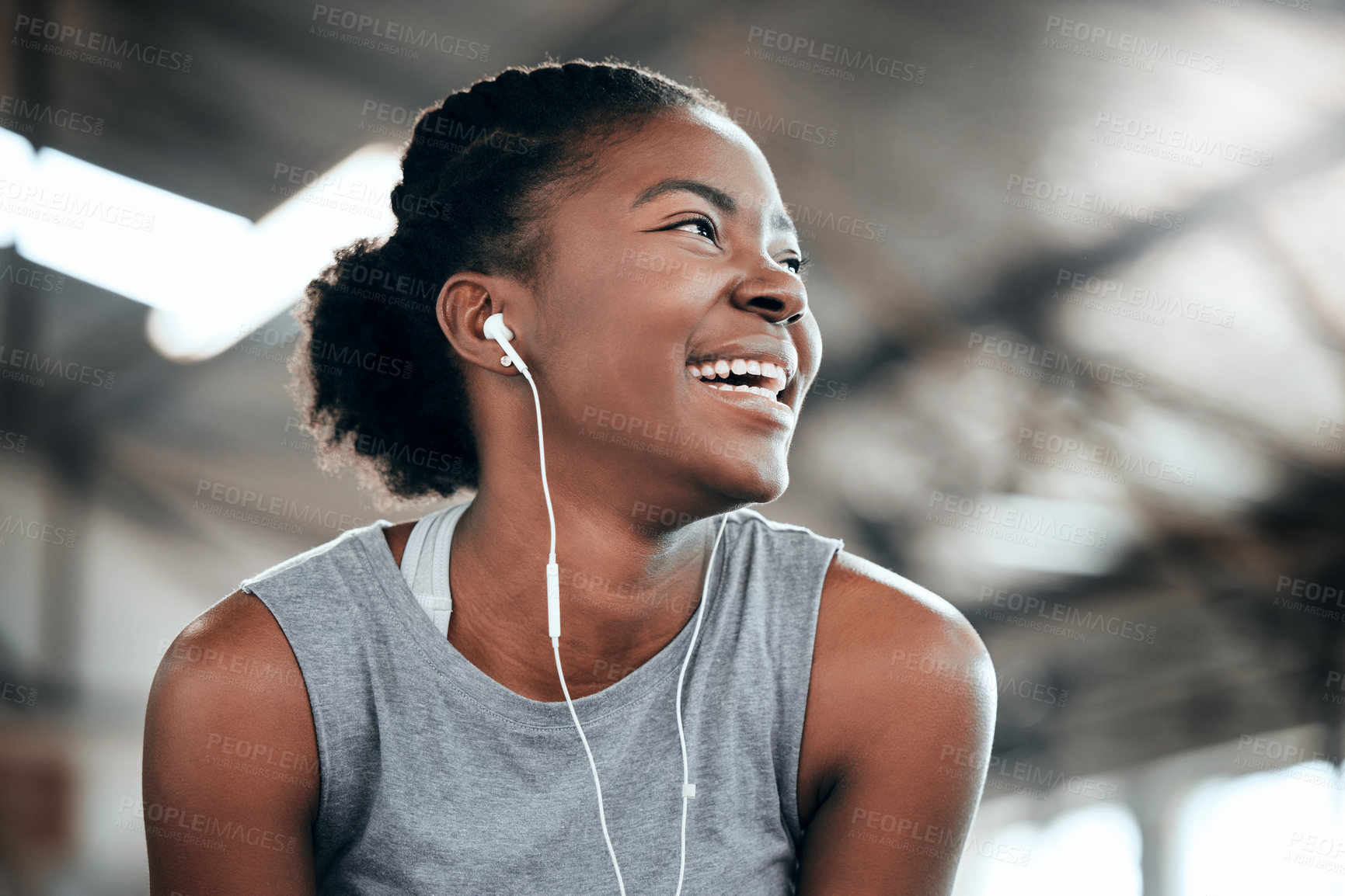 Buy stock photo Shot of a happy woman using earphones at the gym