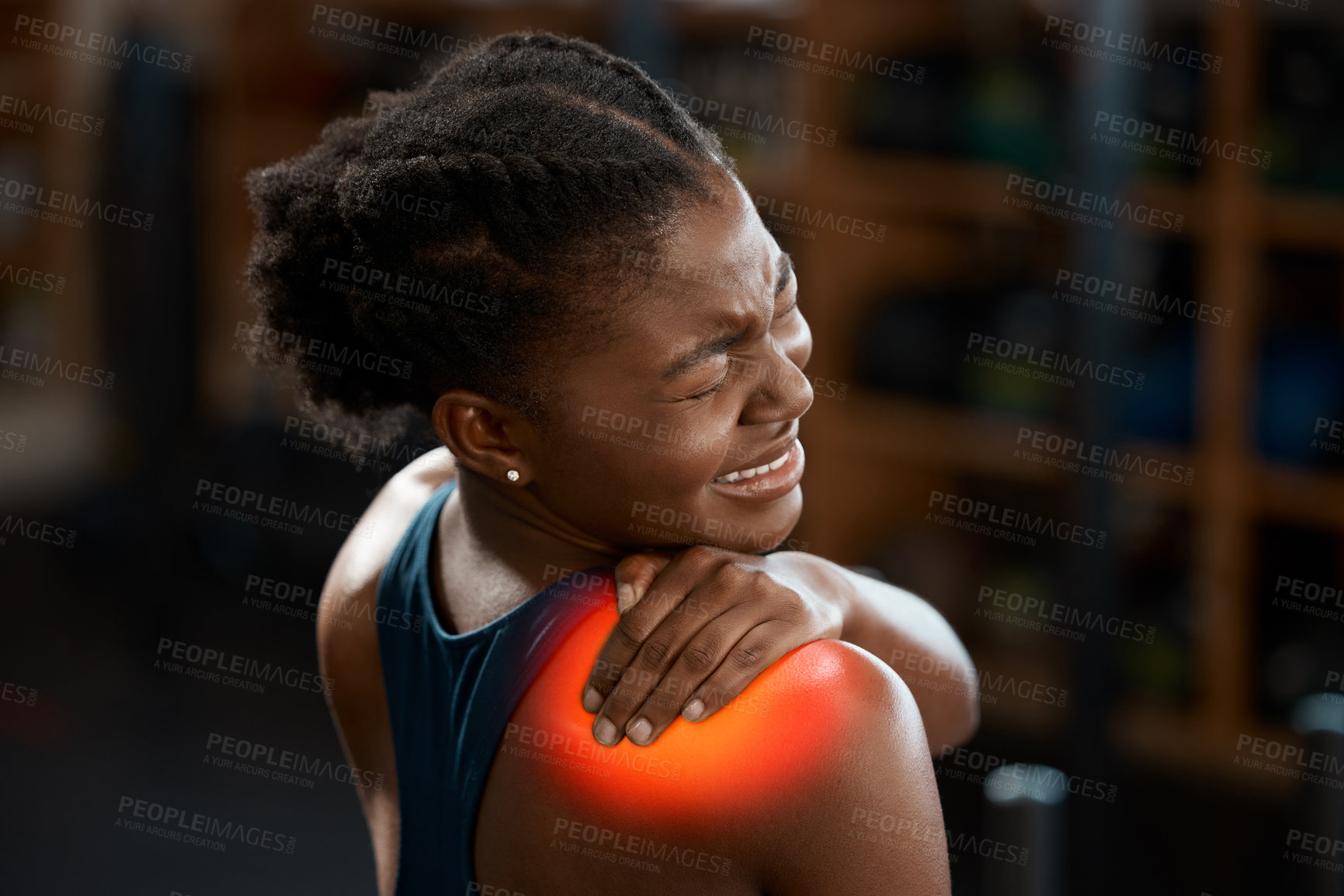 Buy stock photo Rearview shot of an attractive and athletic young woman holding her shoulder in pain while at the gym