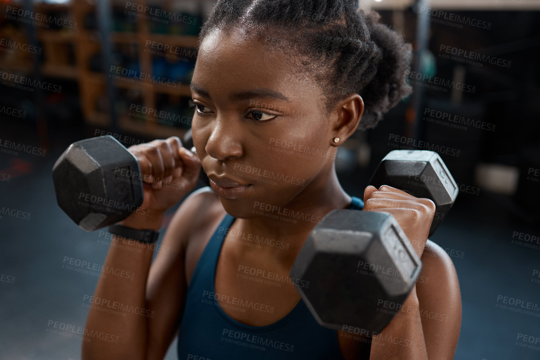 Buy stock photo High angle shot of an attractive and athletic young woman working out with dumbbells in the gym