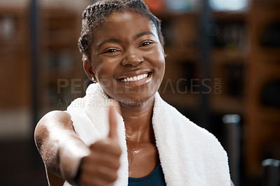 Buy stock photo Cropped portrait of an attractive and athletic young woman giving you thumbs up in the gym