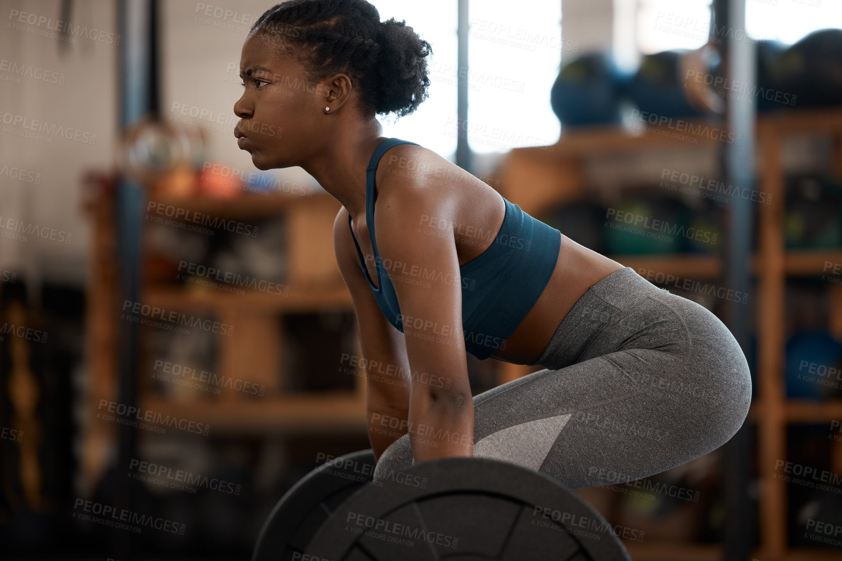 Buy stock photo Cropped shot of an attractive and athletic young woman working out with a barbell in the gym