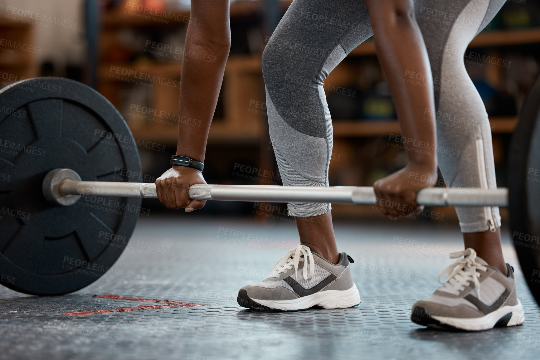 Buy stock photo Cropped shot of an unrecognizable and athletic young woman working out with a barbell in the gym