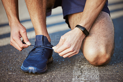 Buy stock photo Man, hands and tying shoes for running, fitness or cardio exercise on asphalt road in the outdoors. Hand of male person, athlete or runner tie shoe getting ready for exercising or training on street