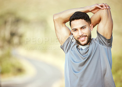 Buy stock photo Portrait of a sporty young man stretching his arms while exercising outdoors