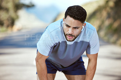 Buy stock photo Fitness, tired man and outdoor with earphones for music on run or workout. Exhausted athlete person or runner listening to audio on break and road for exercise, running and training or breathing
