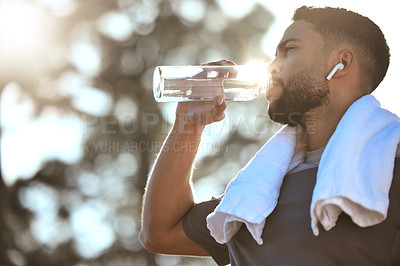 Buy stock photo Man, fitness and drinking water in nature for sustainability, hydration or break after running workout or exercise. Male person or runner with natural drink for healthy wellness or rest from run