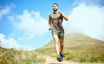 Buy stock photo Low angle shot of a sporty young man running outdoors