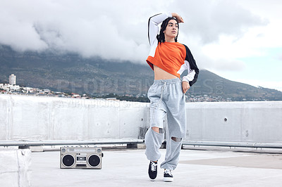 Buy stock photo Shot of a young woman out on a rooftop with a boombox