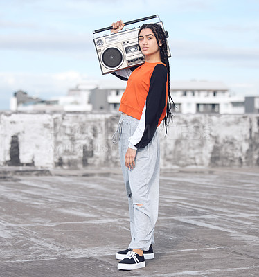 Buy stock photo Shot of a young woman out on a rooftop with a boombox