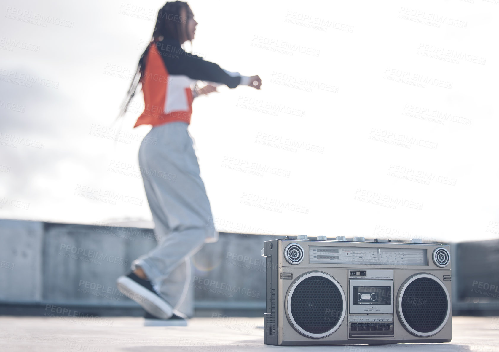 Buy stock photo Shot of a young woman out on a rooftop with a boombox