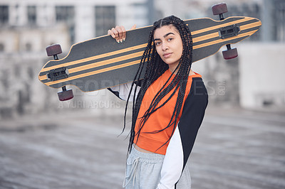 Buy stock photo Shot of a young woman out in the city with her skateboard