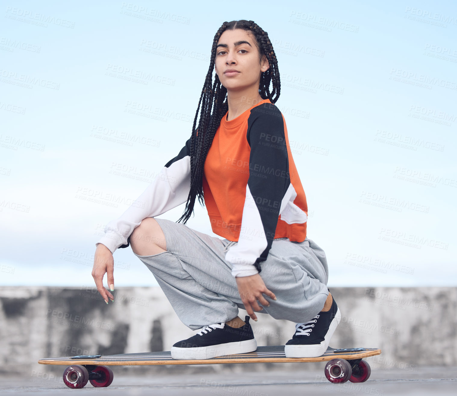 Buy stock photo Shot of a young woman out in the city with her skateboard