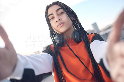 Buy stock photo Shot of a young woman posing with headphones around her neck