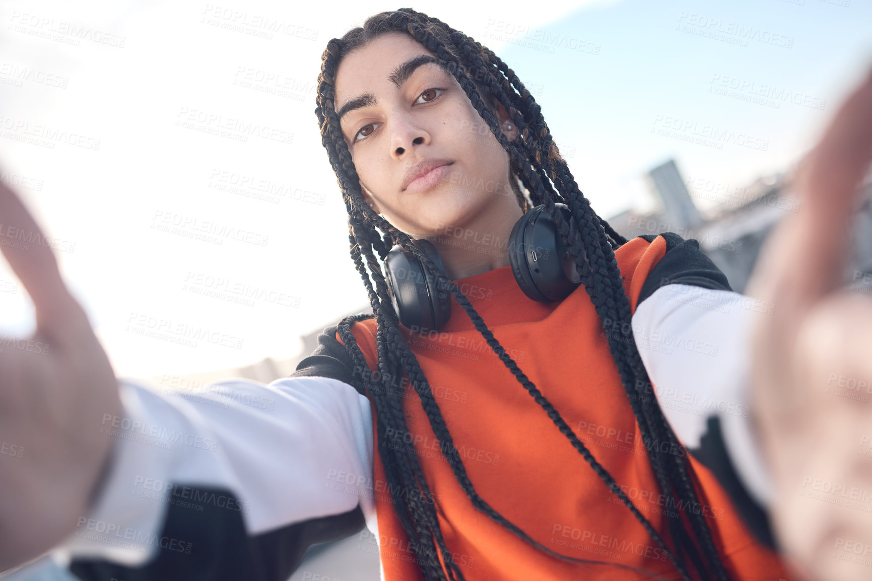 Buy stock photo Shot of a young woman posing with headphones around her neck