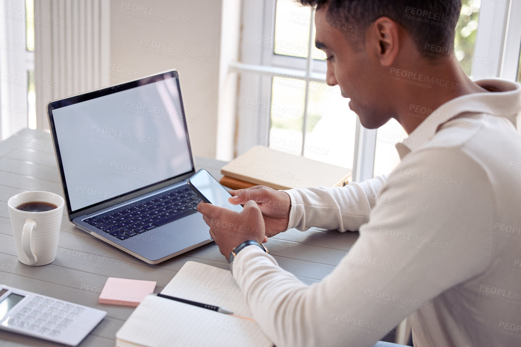 Buy stock photo Shot of a young male using his cellphone at home