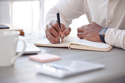 Buy stock photo Shot of an unrecognizable male writing in his diary at home