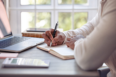 Buy stock photo Shot of an unrecognizable male writing in his diary at home