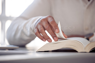 Buy stock photo Shot of an unrecognizable male reading a book at home