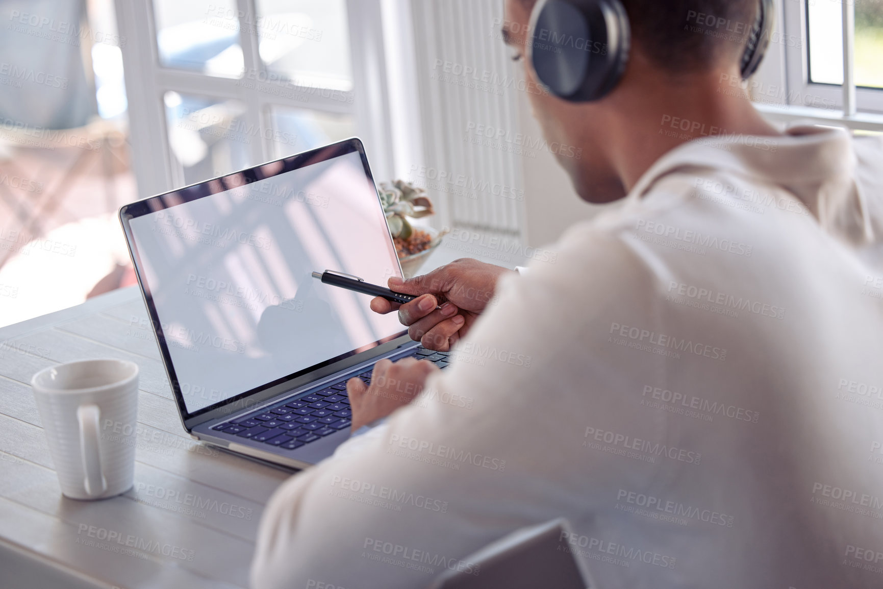 Buy stock photo Laptop, screen and man with headphones at desk for freelance job, planning or multimedia research. Remote work, online and mockup with technology at home for web design, idea and listening to podcast