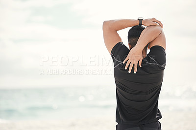 Buy stock photo Shot of a young man stretching on the beach