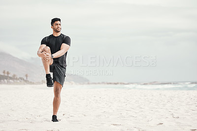 Buy stock photo Shot of a young man stretching on the beach