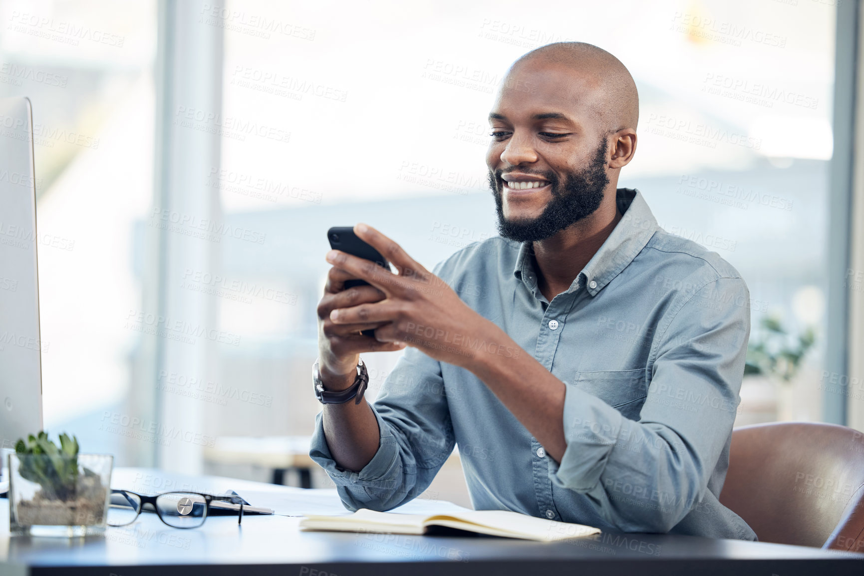 Buy stock photo Black man in office, check social media on smartphone and smile at meme, lunch break and communication. Male employee at workplace, using phone and technology, mobile app and contact with chat 