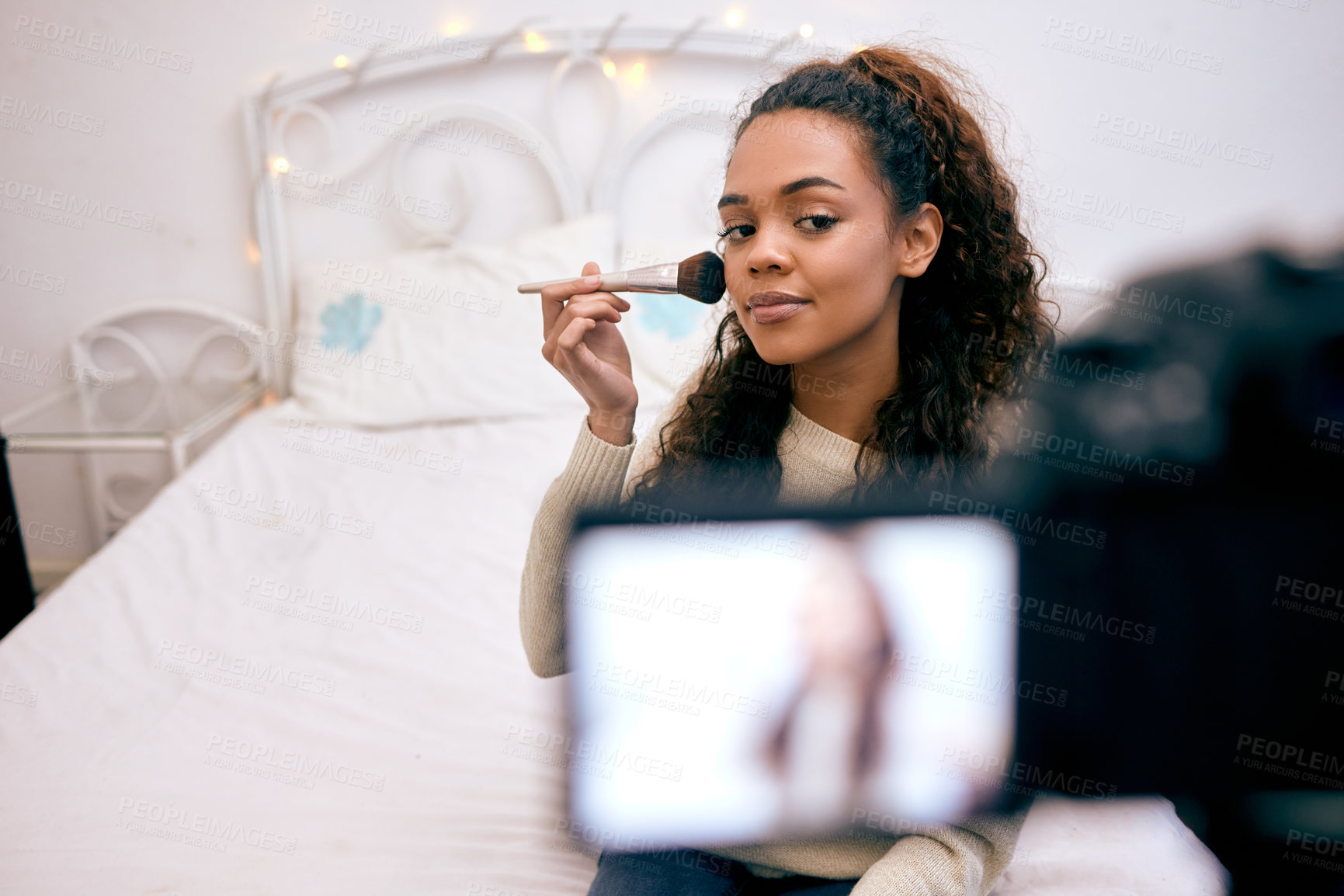 Buy stock photo Shot of a young woman doing her makeup while recording a video for her blog