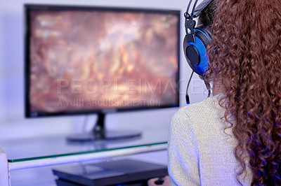 Buy stock photo Rearview shot of a woman wearing a headset while playing video games