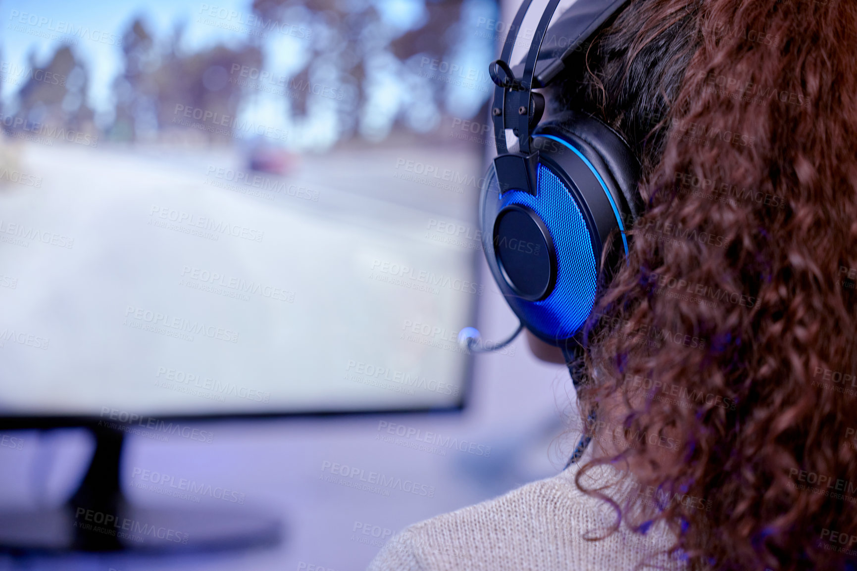 Buy stock photo Rearview shot of a woman wearing a headset while playing video games