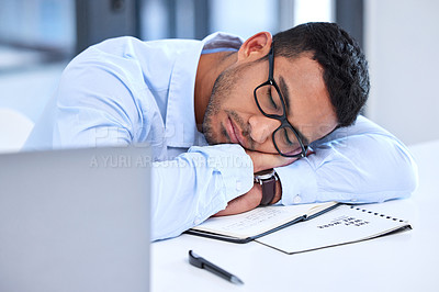 Buy stock photo Shot of a young businessman taking a nap at work