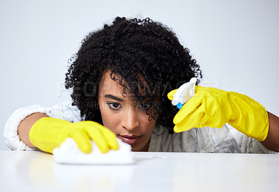 Buy stock photo Shot of a young woman spraying down a counter to clean it