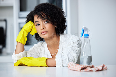 Buy stock photo Shot of a young woman looking unhappy while cleaning her kitchen