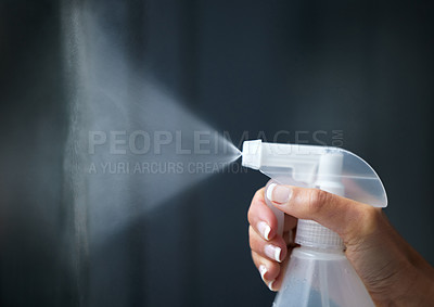 Buy stock photo Shot of a woman spraying bottle of disinfectant to clean her window