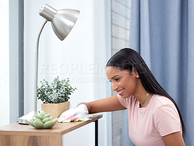 Buy stock photo Shot of a young woman scrubbing down her counter at home