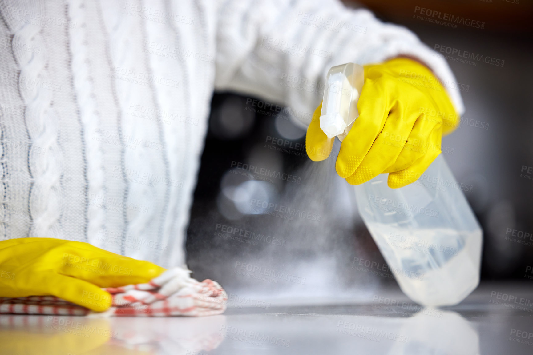 Buy stock photo Shot of a woman spraying her kitchen counter to clean it