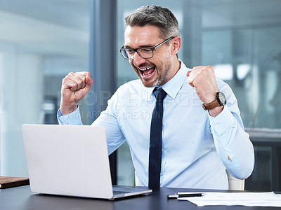 Buy stock photo Shot of a mature businessman cheering while working in an office