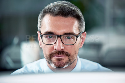 Buy stock photo Shot of a businessman using his computer while sitting at his desk