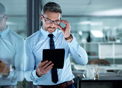 Buy stock photo Shot of a businessman using a digital tablet at the office