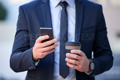 Buy stock photo Cropped shot of an unrecognizable businessman texting while standing outside in the city