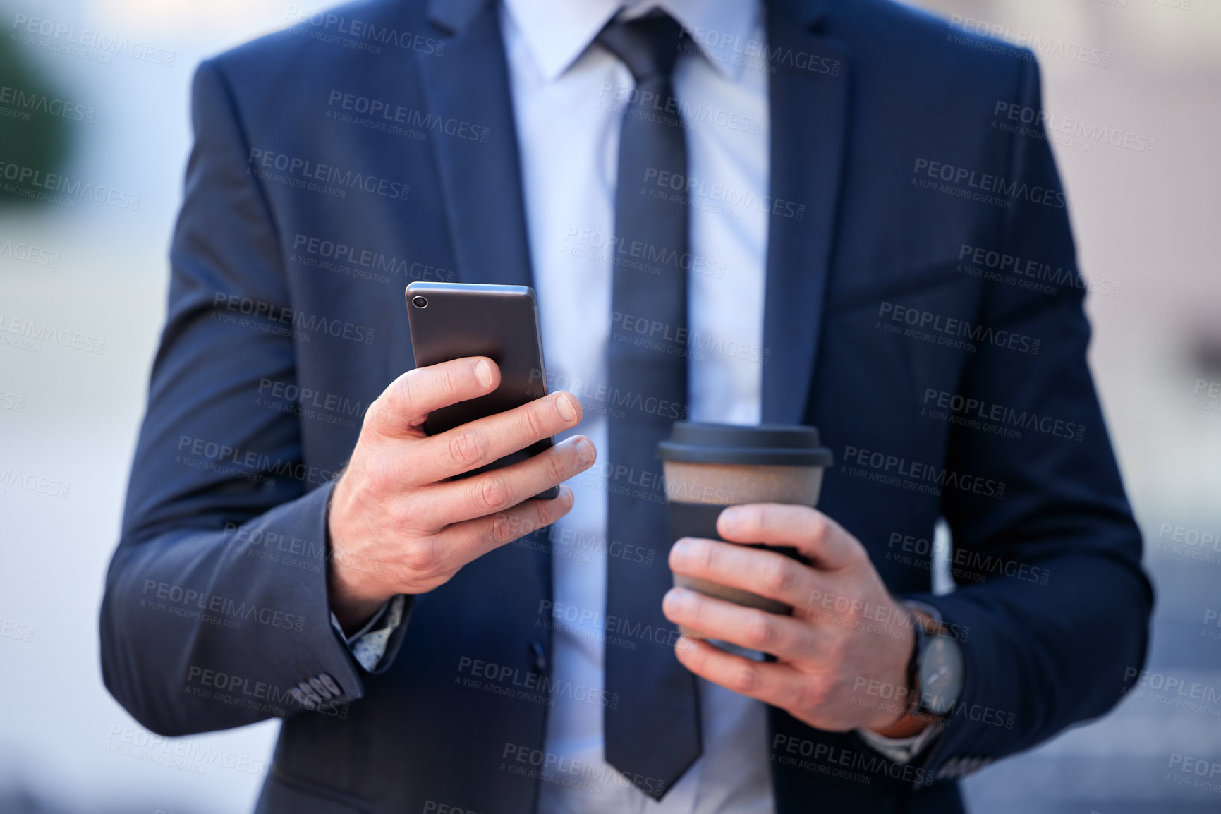 Buy stock photo Cropped shot of an unrecognizable businessman texting while standing outside in the city