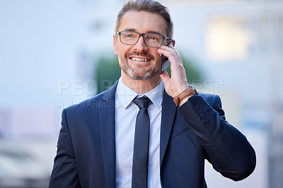 Buy stock photo Cropped shot of a handsome mature businessman making a call while standing outside in the city