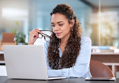 Buy stock photo Cropped shot of an attractive young businesswoman looking thoughtful while working on her laptop in the office