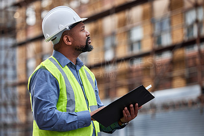 Buy stock photo Shot of a contractor filling out paperwork at a construction site