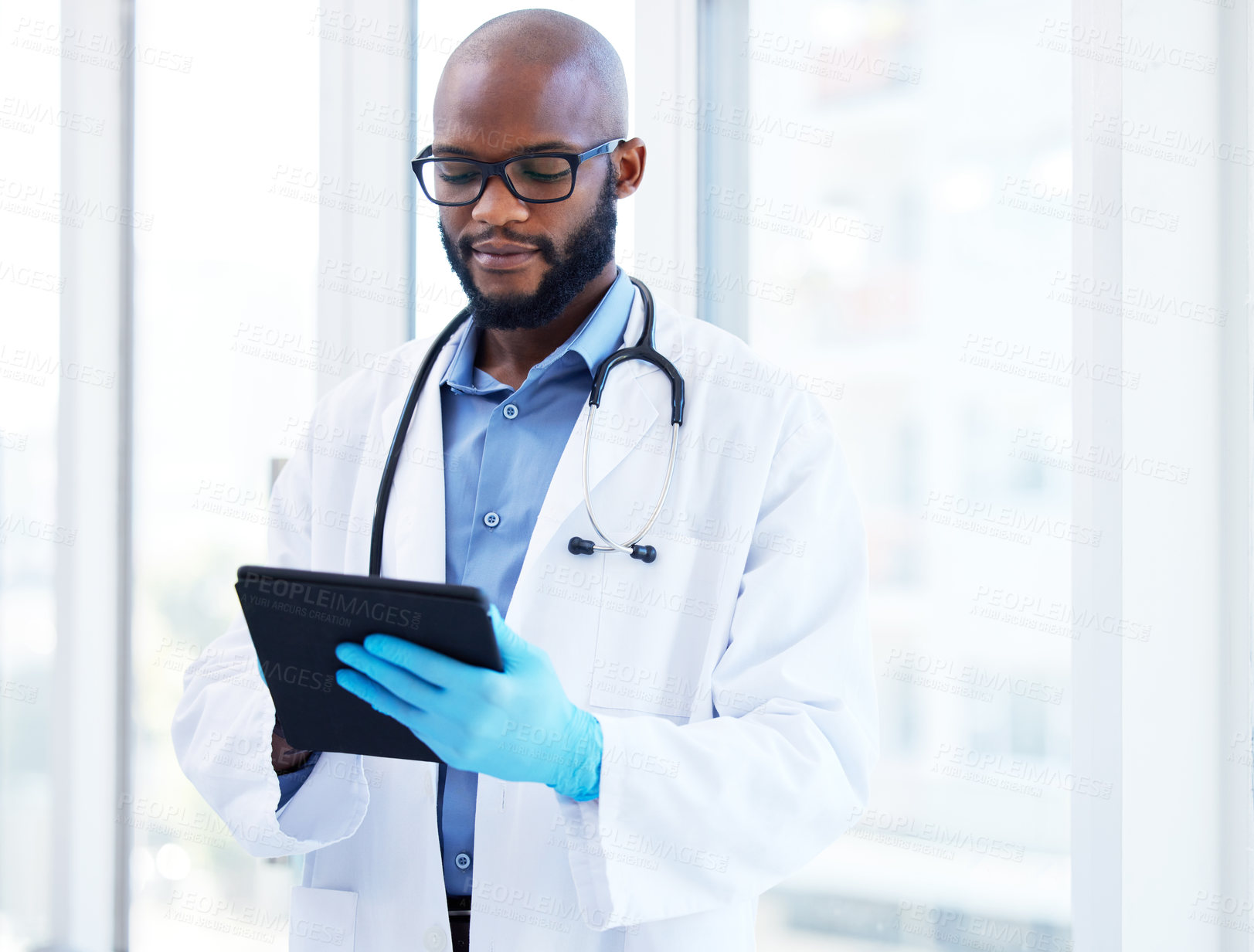 Buy stock photo Healthcare, tablet and black man doctor at hospital for research, planning or schedule. Help, stethoscope or cardiovascular surgeon with digital communication, consulting or Telehealth service app
