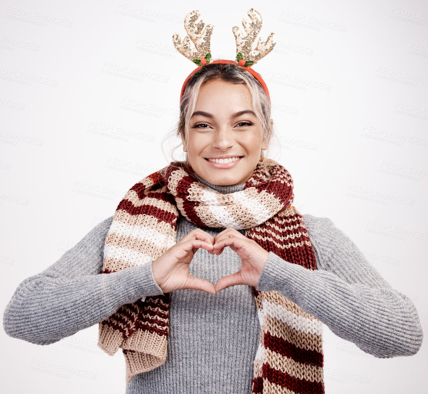 Buy stock photo Christmas, woman and heart with smile in portrait for festive, winter and holiday on studio backdrop. Female person, cheerful and happy in celebration with shape for love in  season for vacation
